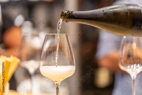 Принти на полотні Pouring sparkling white wine into a glass