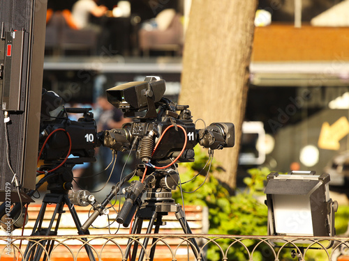 Professional movie cameras on the set among other equipment. Production of a film or report on the streets of the city. Documentary and artistic shooting. Japanese electronics. Videographer and high t