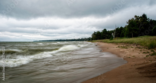 Waves crashing on the sandy shores near  Cave Point along Lake Michigan on a cloudy day
