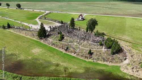 Hill of Crosses, Siauliai, Lithuania — August 1, 2025: Panoramic aerial footage captured by drone. The scene shows thousands of wooden and metal crosses, walking paths and the surrounding countryside 