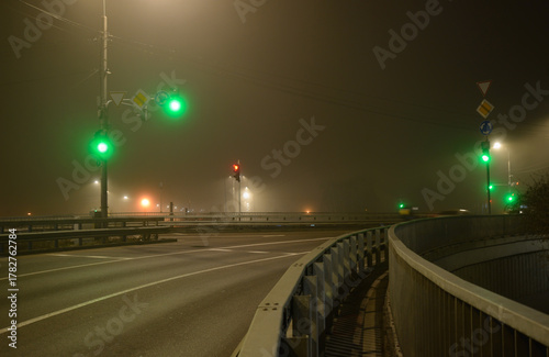 Empty city crossroads at night in foggy winter weather
