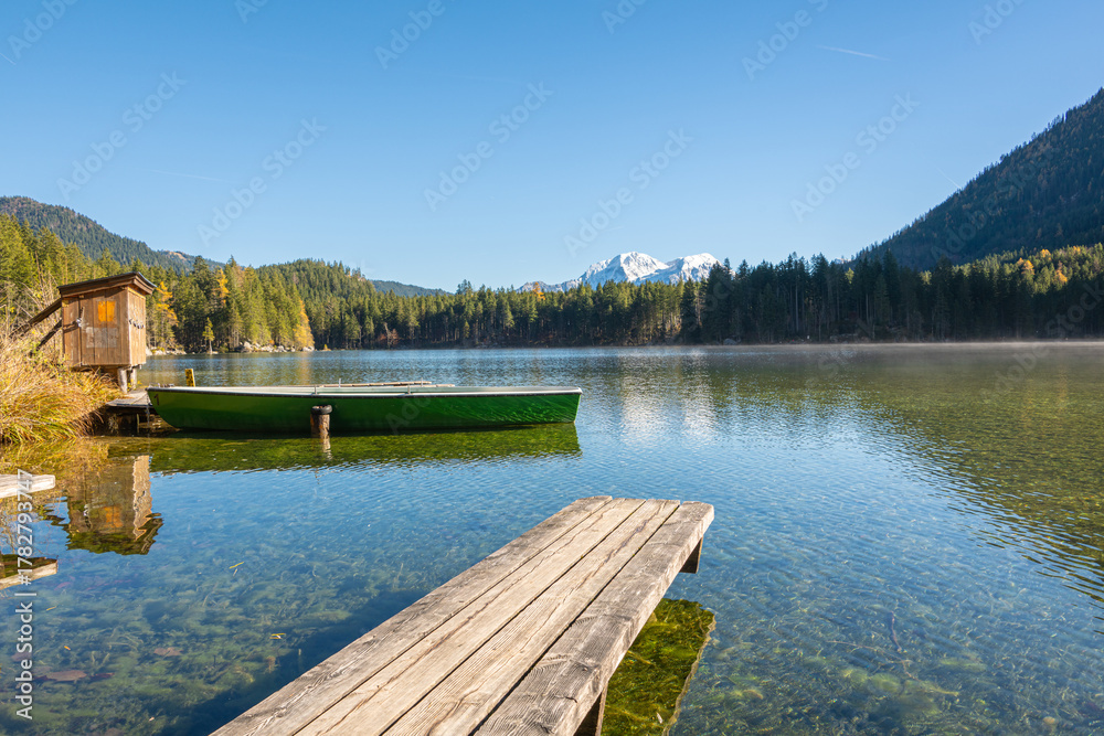 Obraz premium Boat and wooden web at the see surrounded by high mountains and forests