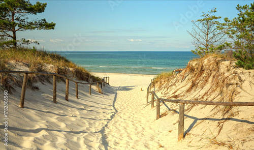 spokojny widok na wejście na piaszczystą plażę morską z szumiącym morzem w oddali