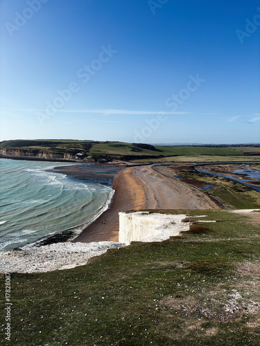 Panoramic view of Seven Sisters Cliffs along the East Sussex coast with blue sky and sandy beach