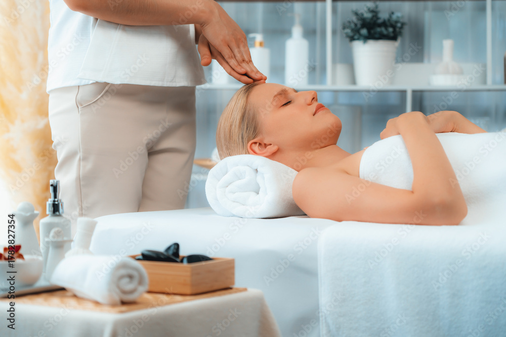 Naklejka premium Caucasian woman enjoying relaxing anti-stress head massage and pampering facial beauty skin recreation leisure in dayspa modern light ambient at luxury resort or hotel spa salon. Quiescent