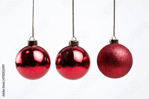 Three red, round Christmas ornaments dangling in a row