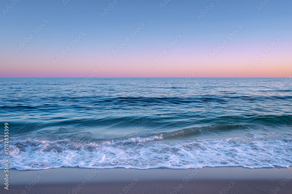Obraz premium A serene beach scene with soft waves in sunset