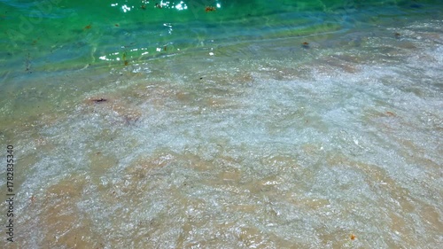 Close up view of waves of emerald green Atlantic Ocean rolling gently on sandy beach. Miami Beach. USA.