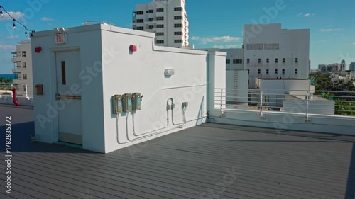 Close up view of observation part of hotel rooftop building with white walls and city view on background. Miami Beach. USA.
