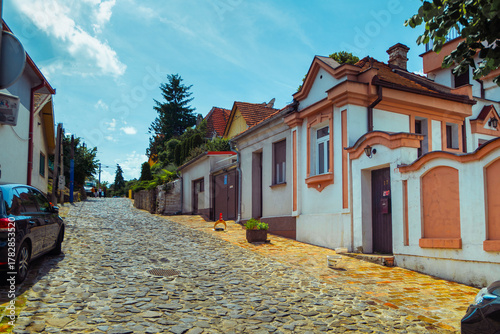 Charming Cobblestone Street with Picturesque Historic Houses on a Sunny Day