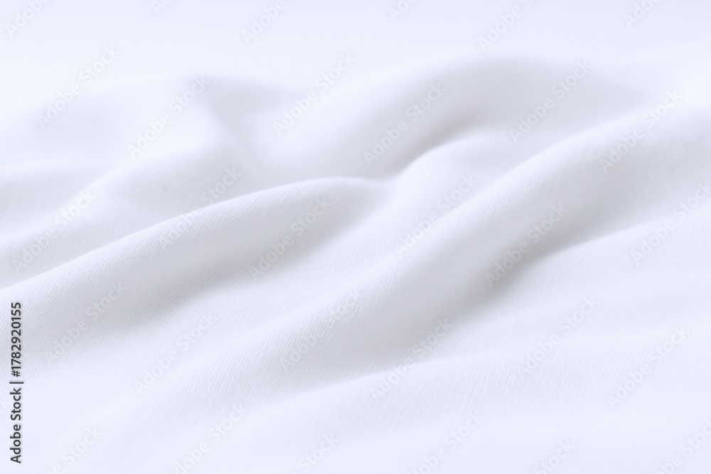 Naklejka premium Elegant White Fabric Texture with Soft Folds and Gentle Light, Ideal for Backgrounds or Overlays
