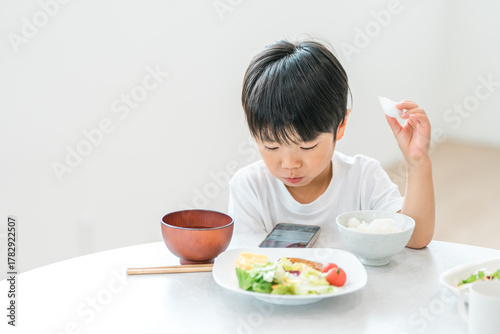 Digital meal while looking at mom's smartphone, child eating meal, toddler, boy

