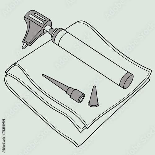 An otoscope with eartips lying on a folded cloth