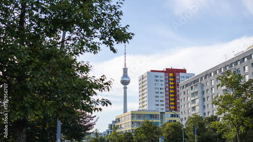 View of a Berlin street in summer with residential buildings and the Berlin TV Tower in the background