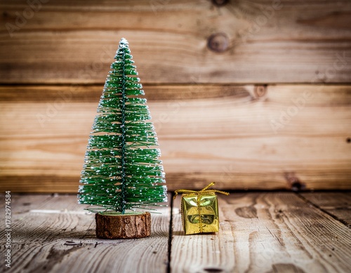 Mini Christmas Tree with Small Gift Box on Rustic Wooden Background