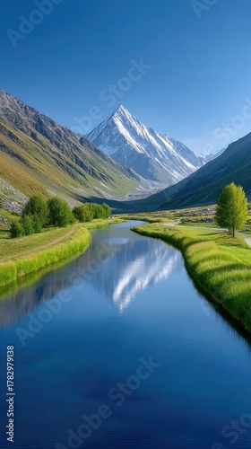 Majestic Snow Capped Mountain Peaks Reflected in a Winding Blue River Amidst Lush Green Valleys Under a Clear Blue Sky