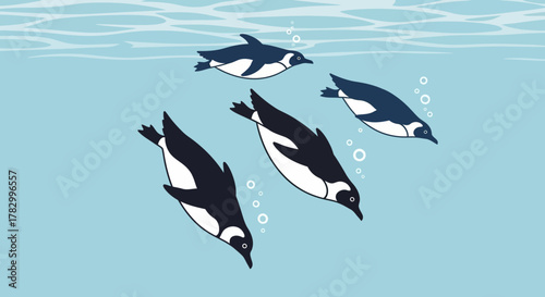 Penguins swimming underwater in blue ocean