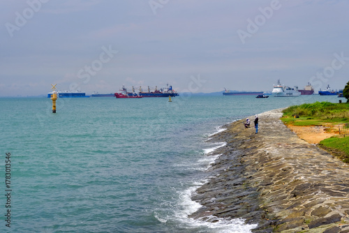 Singapore - East coast park walking trail - Coastline with anglers and anchored cargo ships