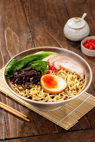 Ramen. Spicy noodle soup with egg, grilled chicken, seaweed and bok choy in a bowl