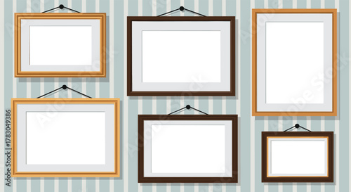 A collection of various empty picture frames, both landscape and portrait, hanging neatly on a light blue and white striped wall, ready for personalization.