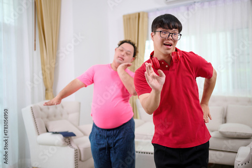 A man with down syndrome is dancing in the living room, a vibrant and inclusive gathering with friends