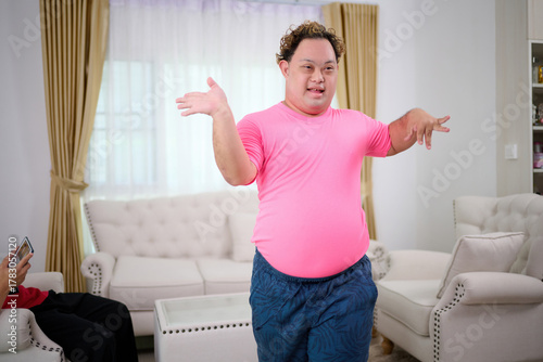 A man with down syndrome is dancing in the living room