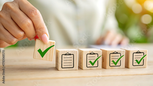 Hand placing wooden block with check mark on top of others with document