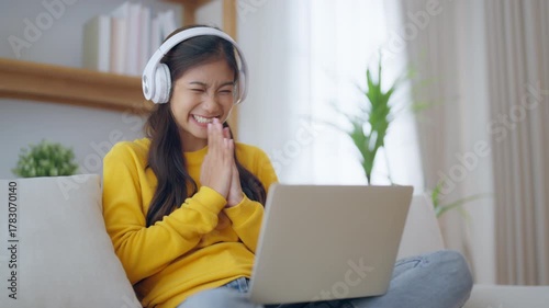 Funny euphoric young asian woman celebrating winning or getting ecommerce shopping offer on computer laptop. Excited happy girl winner looking at notebook celebrating success