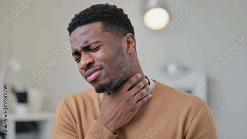 Throat Pain: A close-up shot of a man experiencing throat pain, conveying the discomfort with visible expression. 