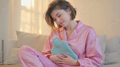 Warm Comfort: A young woman finds solace with a hot water bottle, a moment of gentle tranquility. 