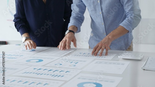 Valokuva Business professionals analyzing financial charts, gesturing over spreadsheets d