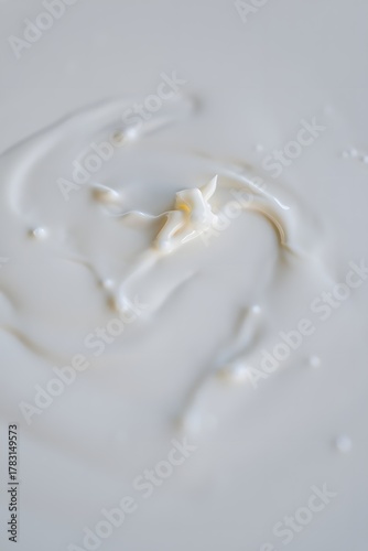 White liquid with a splash creating abstract patterns and textures in a smooth surface