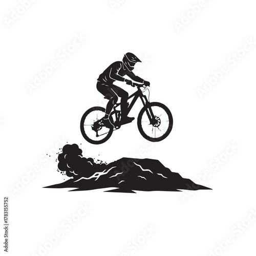 Silhouette of a mountain biker performing a jump in midair.