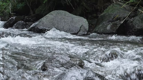Clear water of the mountain river flows through the rocky contours of the river. The river water flows leisurely on the mountain rocks.