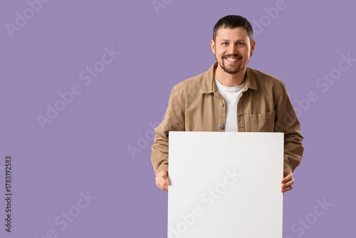 Young man with blank poster...