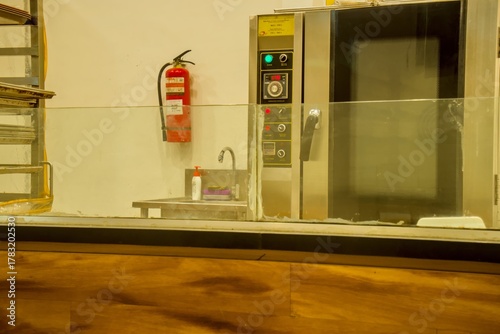 Commercial kitchen with stainless steel oven, sink, and fire extinguisher