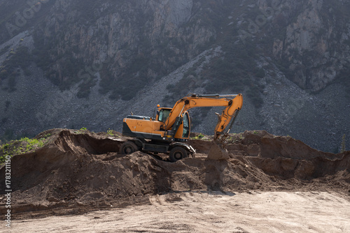Wallpaper Mural yellow excavator working on sandy ground near mountain slope on sunny day, special equipment in mountain nature Torontodigital.ca