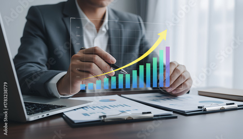Analyzing financial growth data with upward trending chart, business professional reviewing market analysis for strategic investment decisions, success concept