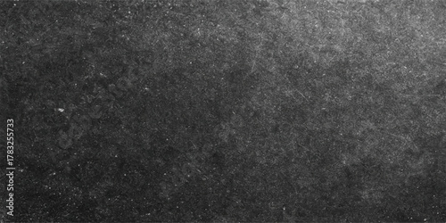 Dark gray asphalt texture background, a rough street material surface pattern with patches of black and white snow