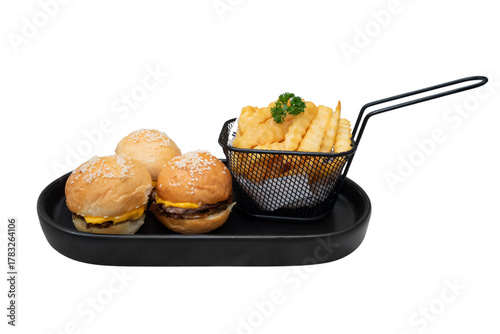 Mini burgers and fries are arranged on the black plate, ready to be served. A delicious meal that is perfect for any occasion. The burgers have soft buns, the fries look golden and crispy.