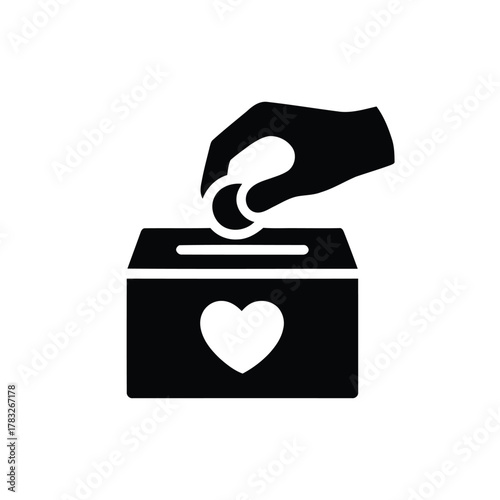 Hand putting coin in donation box with heart