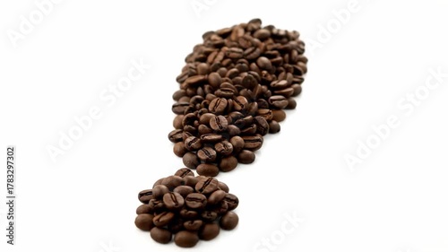 A close-up shot of roasted coffee beans artfully arranged in the shape of an exclamation point against a white backdrop