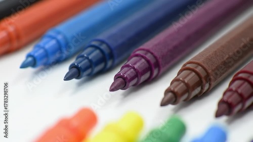 A close-up showcases a collection of colored pens, showcasing a diverse palette of vibrant hues, with a shallow depth of field