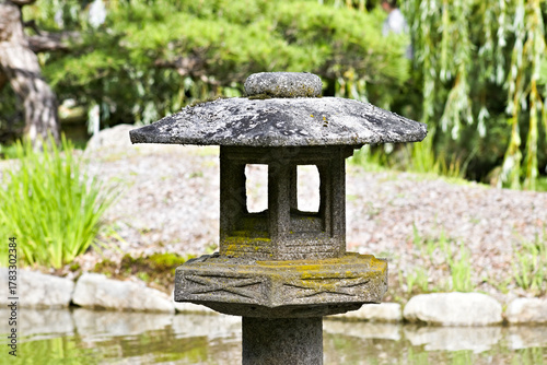 Photography Traditional stone lantern stands beside a pond in the Seattle Japanese Garden, symbolizing peace, culture, and timeless Japanese craftsmanship