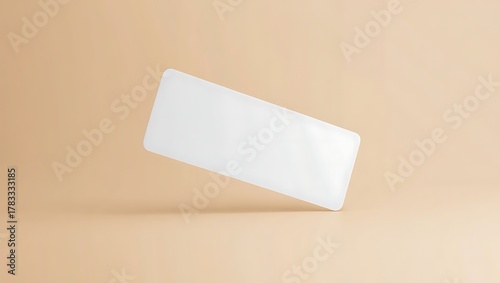 A white, rectangular object hovers diagonally against a soft, beige background, casting a subtle shadow.