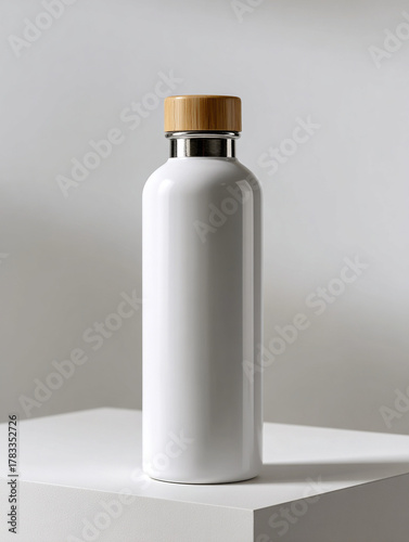 Botella térmica blanca brillante con tapa de madera sobre superficie blanca y fondo suave
