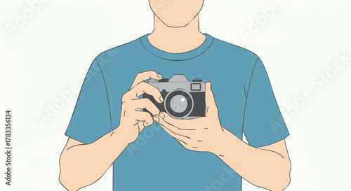 Man holding a camera, capturing moments, taking photographs, photography hobby, creative pursuit, visual storytelling.
