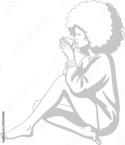 Woman with afro sits and enjoys a warm beverage