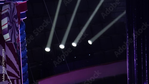 Close-up of stage lighting in a dark theater. Bright beams of light shine through the darkness, creating a dramatic and moody atmosphere. Ideal for event, concert, and lighting concepts
