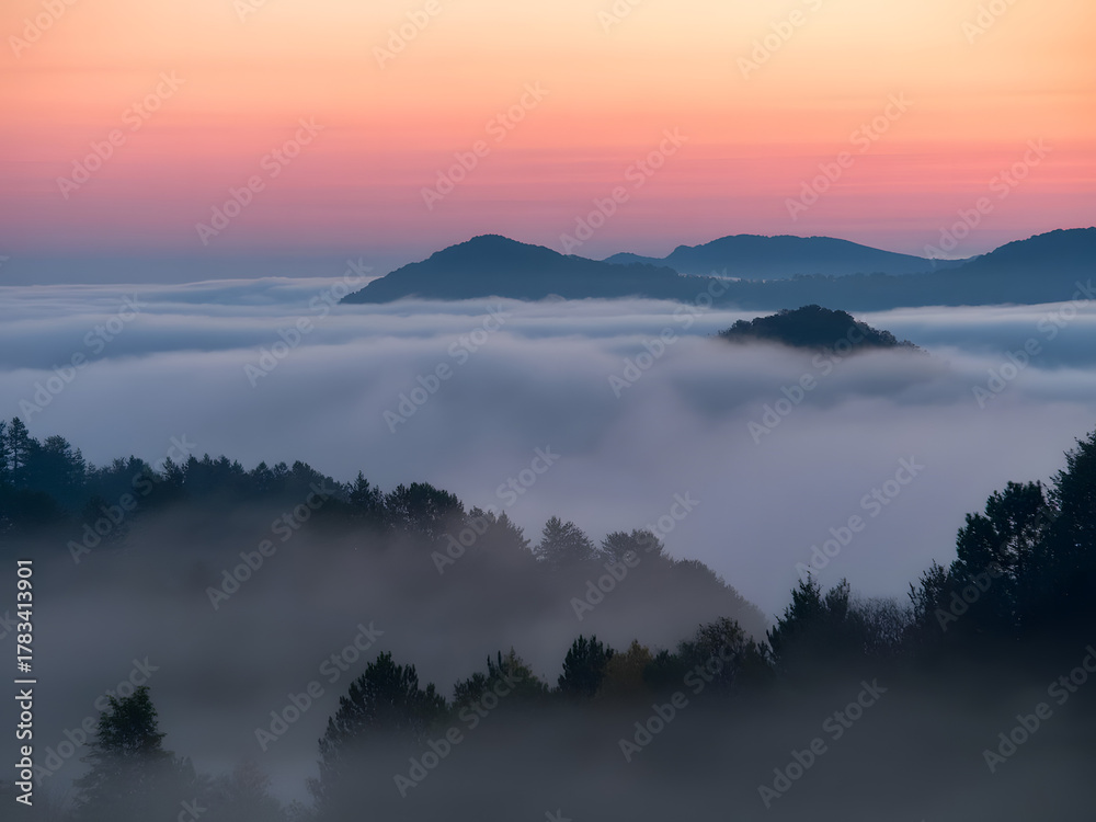 Obraz premium Scenic Mountain Landscape with Fog and Sunrise. Beautiful Nature View of Misty Hills and Colorful Sky at Dawn